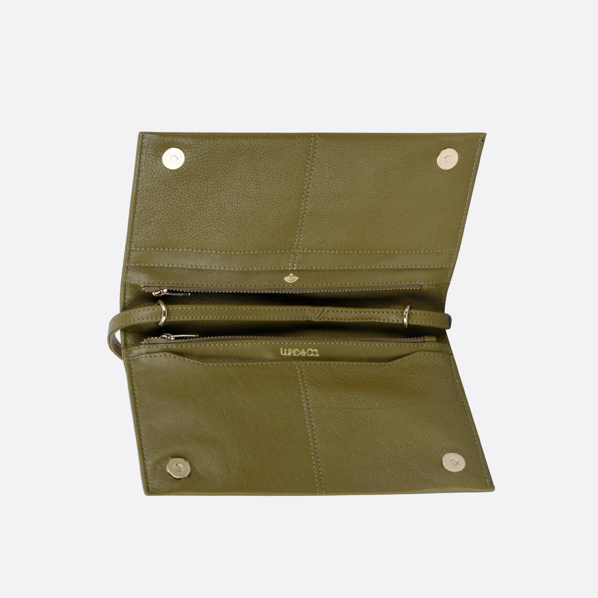 Open view of SOMMARLOV green leather clutch showing internal compartments